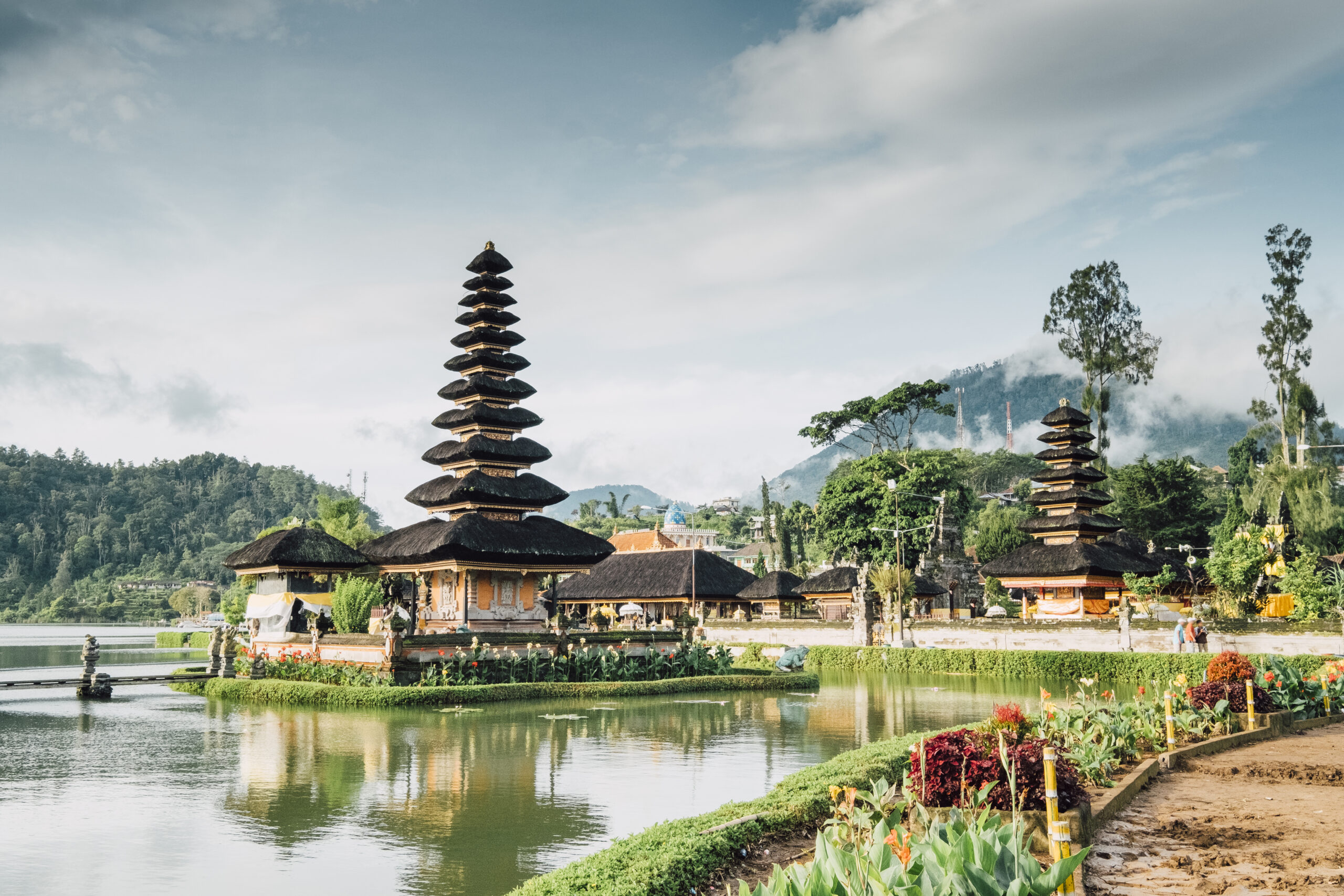 Traditional Balinese temple surrounded by tropical greenery and lake waters.