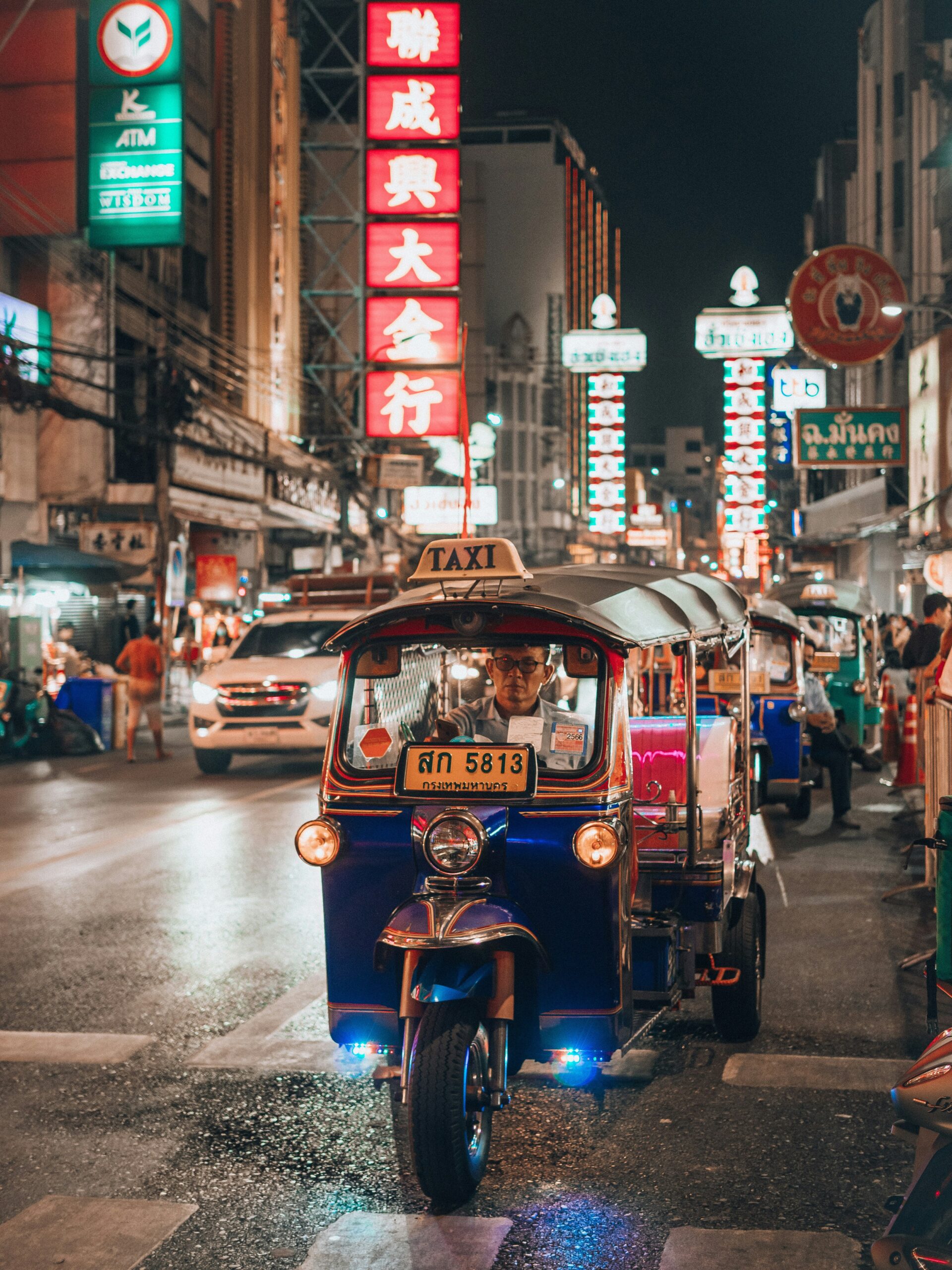 Colorful tuk-tuk on a busy Bangkok street, a popular mode of transport reflecting everyday life and cultural facts about Thailand.