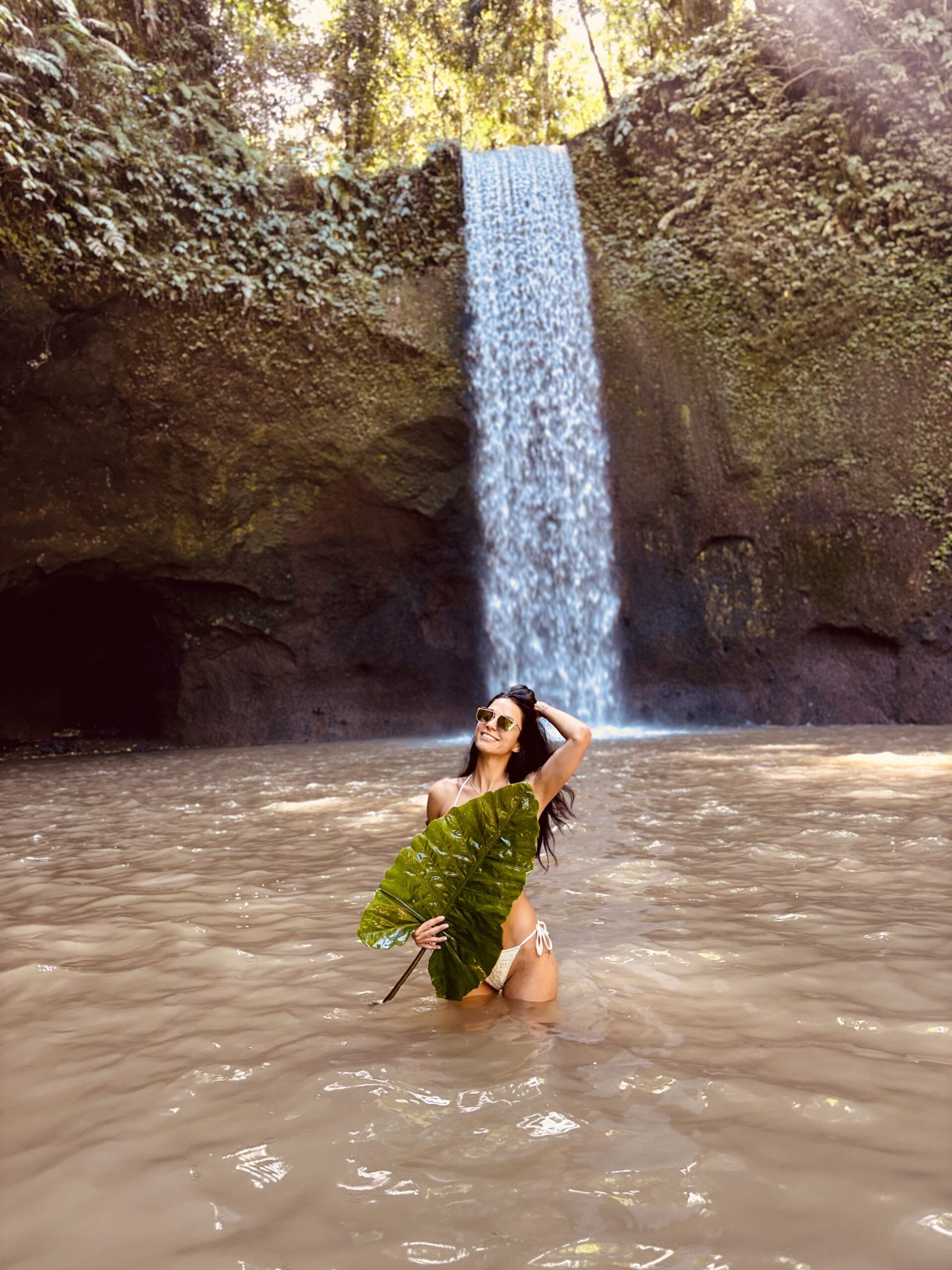 Me standing in front of Tibumana Waterfall in Bali, enjoying the peaceful natural surroundings.